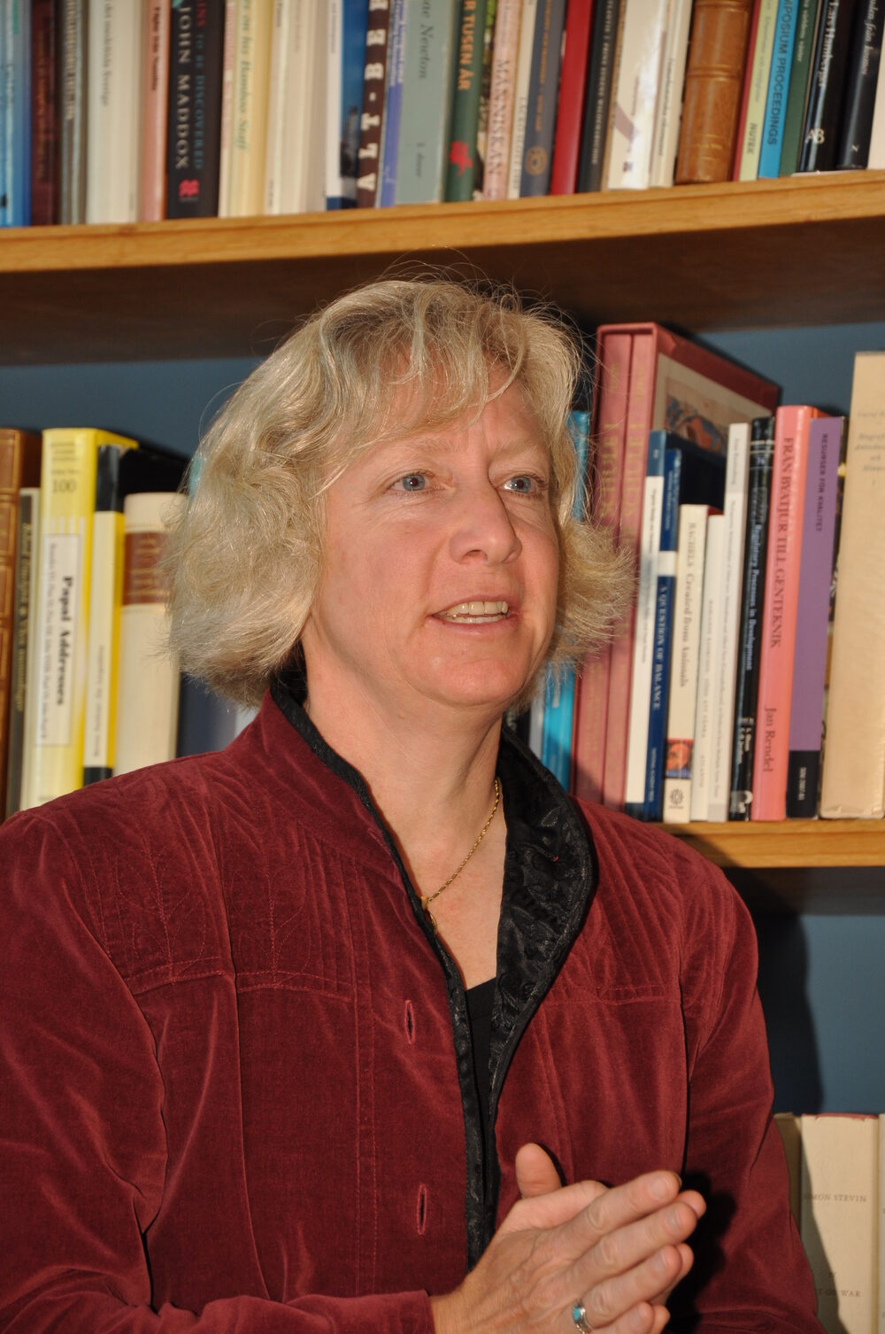 Gretchen Daily speaking in front of a bookshelf