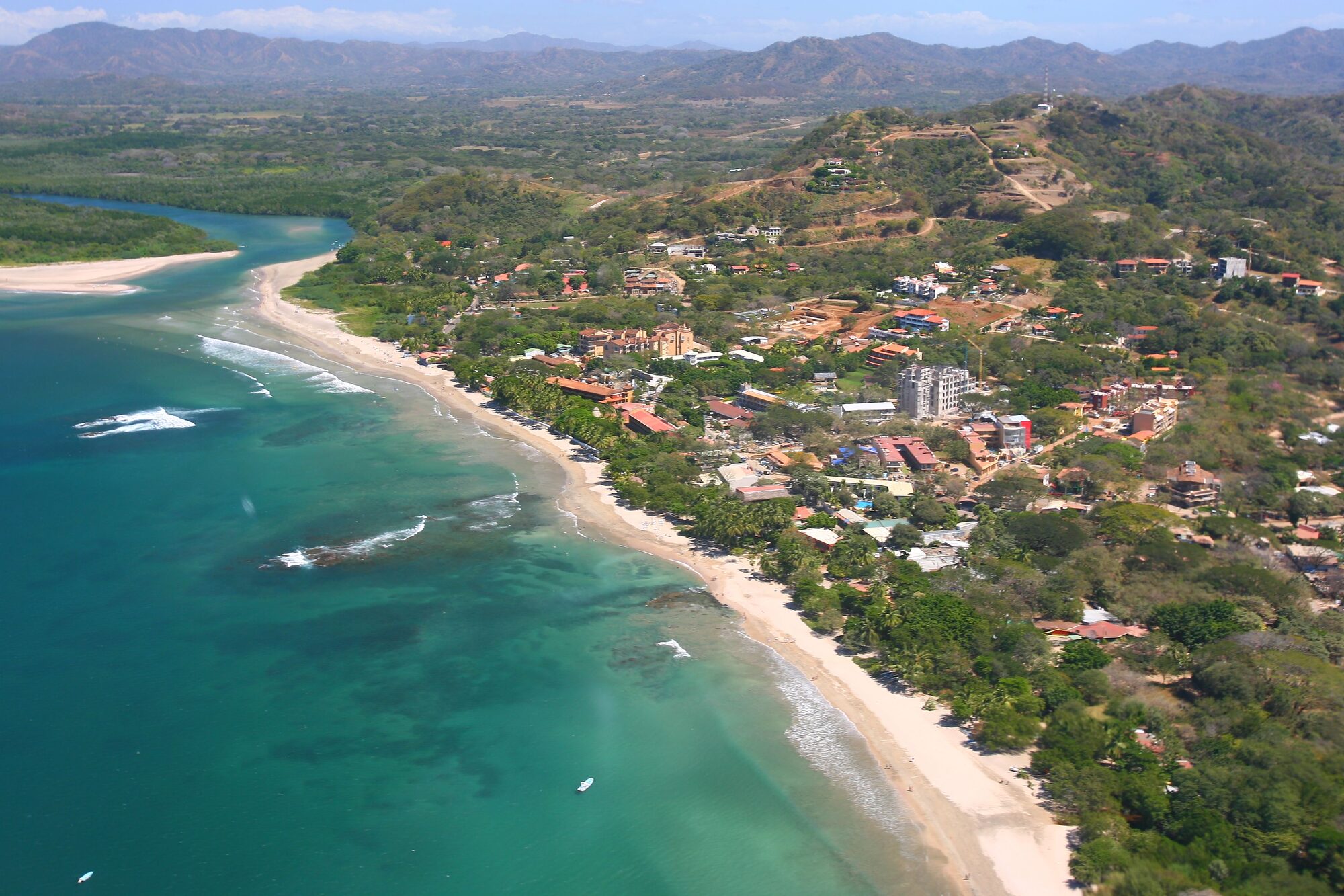 Aerial view of Tamarindo, Costa Rica showing coastal development with hotels, resorts, and the river estuary along the Pacific coastline