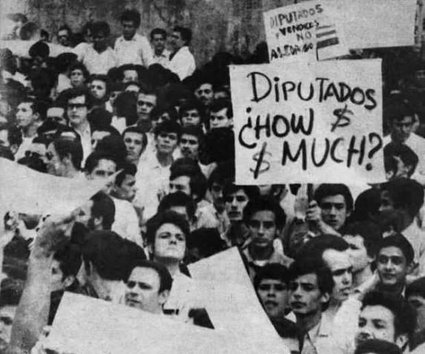 Students protesting the ALCOA contract outside Costa Rica's Legislative Assembly, 1970, holding signs reading 'Diputados: How $ Much?'