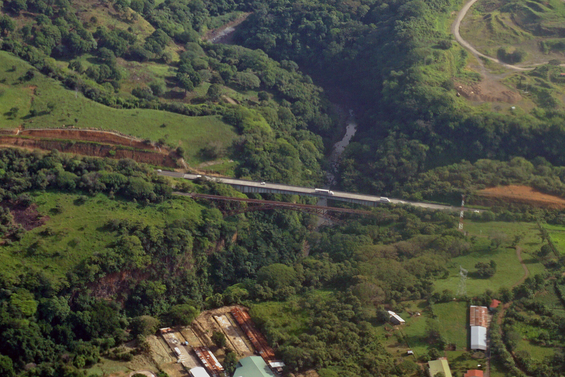 Aerial view of bridges crossing Rio Grande with forested areas and agricultural land in Costa Rica